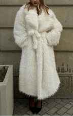 Woman wearing a long white faux fur coat cinched with a matching belt