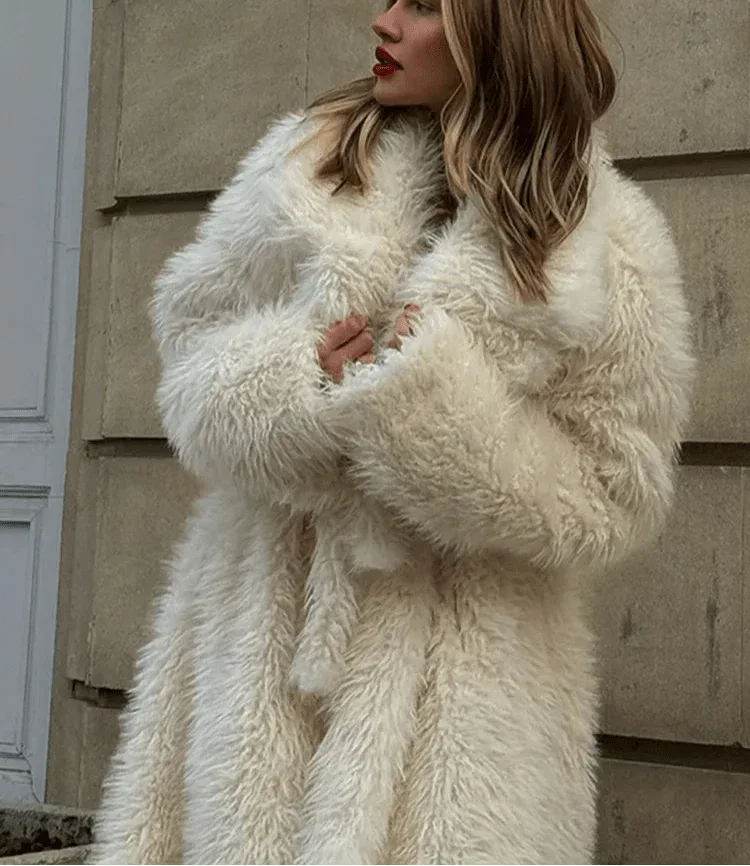 Close-up of a woman's face and chest wearing a long white faux fur coat