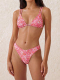 Woman wearing a pink floral print triangle bikini top and matching thong bikini bottom.