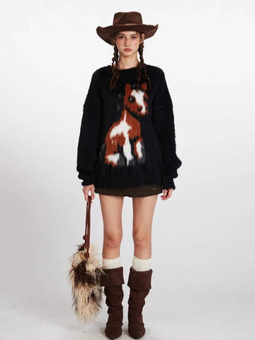 Woman wearing a black fuzzy knit sweater with a brown and white horse graphic on the front, paired with a brown cowboy hat, olive green shorts, white socks, and brown boots.