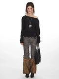 Woman wearing a black off-the-shoulder knit sweater with cinched waist and long sleeves.
