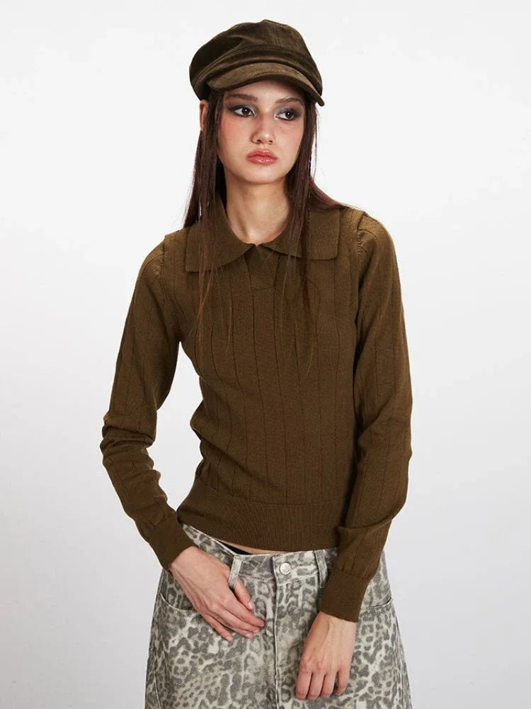 Front view of a model wearing a brown collared knit top and patterned pants.