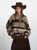 Woman posing in a striped knit sweater, brown skirt, and cowboy hat