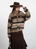 Woman adjusting her cowboy hat while wearing a striped knit sweater