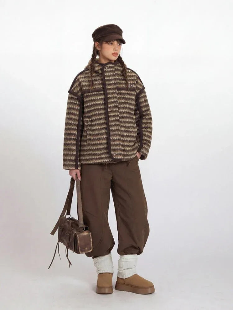 Front view of a woman in a striped fleece jacket and brown pants.