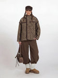 Model wearing a brown and beige striped fleece jacket with a hood.