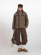 Model wearing a brown and beige striped fleece jacket with a hood.