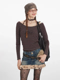 Front close-up of a woman wearing a striped off-the-shoulder top and denim skirt