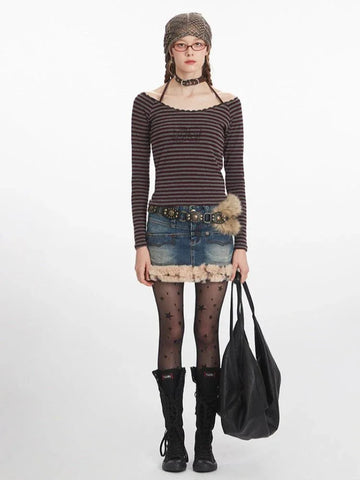 Woman wearing a striped off-the-shoulder long-sleeve top with a denim skirt and black boots