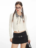 Front view of a woman in a white cropped ribbed knit cardigan