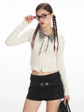 Woman adjusting her glasses while wearing a white cropped ribbed knit cardigan