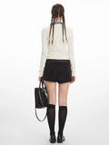 Back view of a woman in a white cropped ribbed knit cardigan