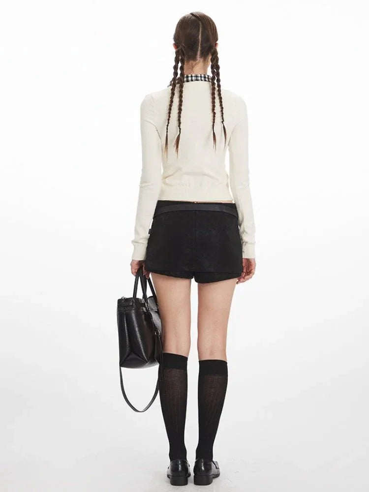 Back view of a woman in a white cropped ribbed knit cardigan
