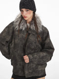 Front view of a woman modeling a textured faux leather jacket with a faux fur collar and acid wash effect, black shorts, and knee-high boots.