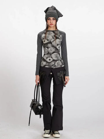 Woman wearing a grey long-sleeve top with a teddy bear print on the front and black pants.