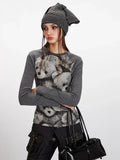 Close-up of a woman wearing a grey long-sleeve top with a teddy bear print.