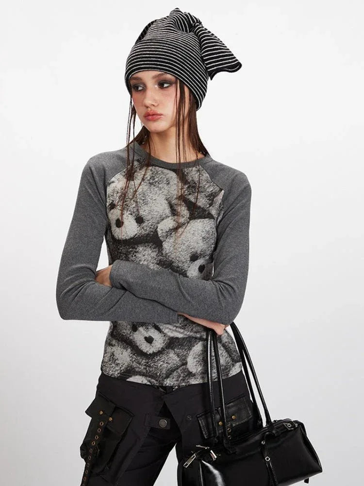 Close-up of a woman wearing a grey long-sleeve top with a teddy bear print.