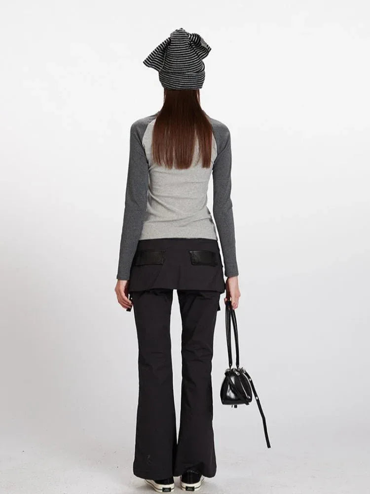 Woman wearing a grey long-sleeve top with a teddy bear print on the front and black pants.