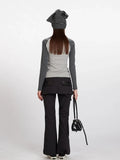 Back view of a woman wearing a grey long-sleeve top with a teddy bear print and black pants.