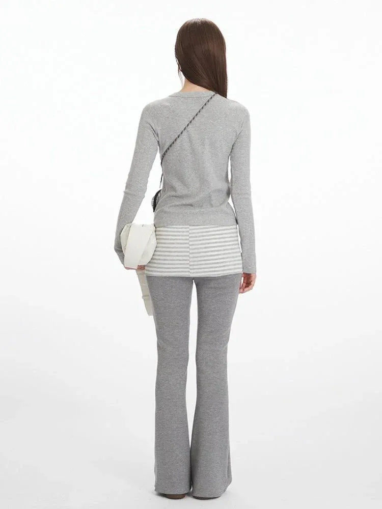 Back view of a model in a grey long-sleeve top and grey flared pants.