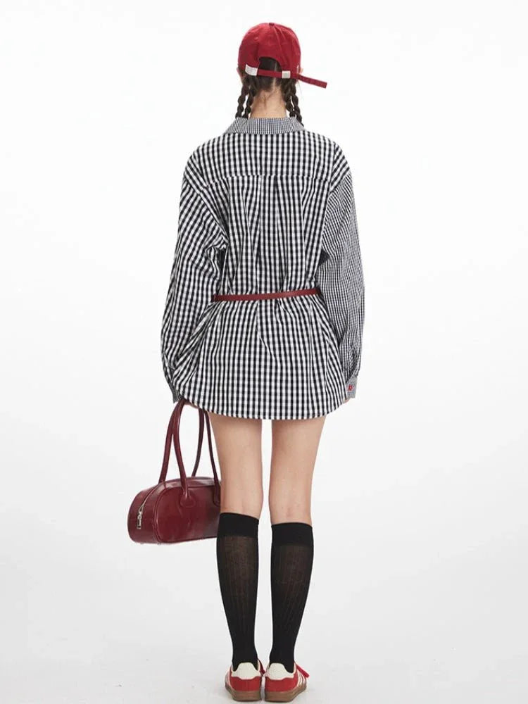 Rear view of a woman in a black and white asymmetrical gingham shirt, red belt, black shorts, and black knee-high socks.