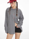 Front view of a woman wearing an oversized black and white gingham shirt with a contrasting pattern, red buttons, and a red belt, with one hand inside her shorts.