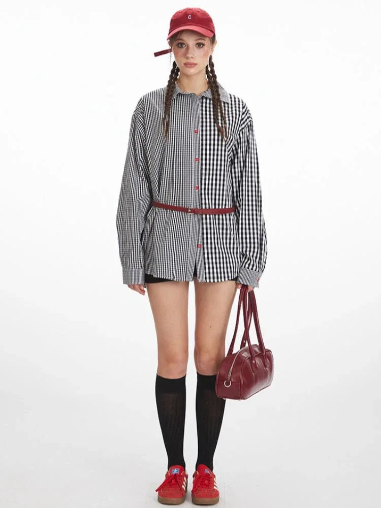 Woman wearing an oversized black and white gingham shirt with a contrasting pattern on each side, red buttons, and a red belt, paired with black shorts and a red baseball cap.