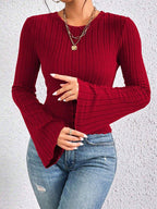 Detail of the flared sleeve on a red ribbed knit top.