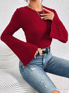Fashion shot of a red ribbed knit top with statement flared sleeves.