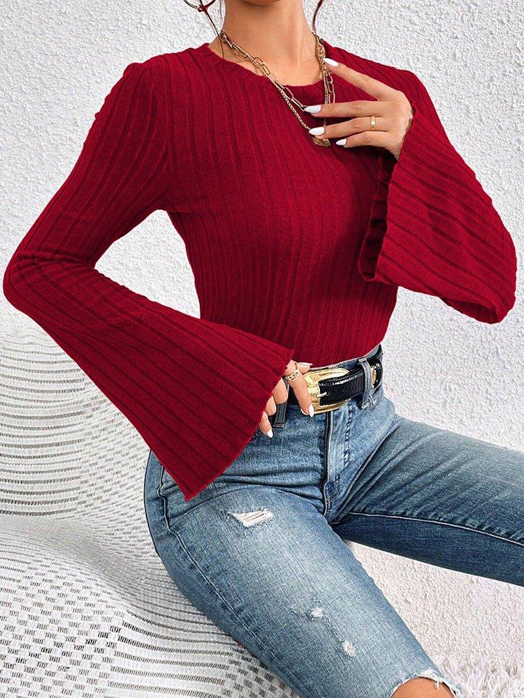 Fashion shot of a red ribbed knit top with statement flared sleeves.