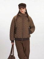 Close-up of the brown quilted bomber jacket on a model.