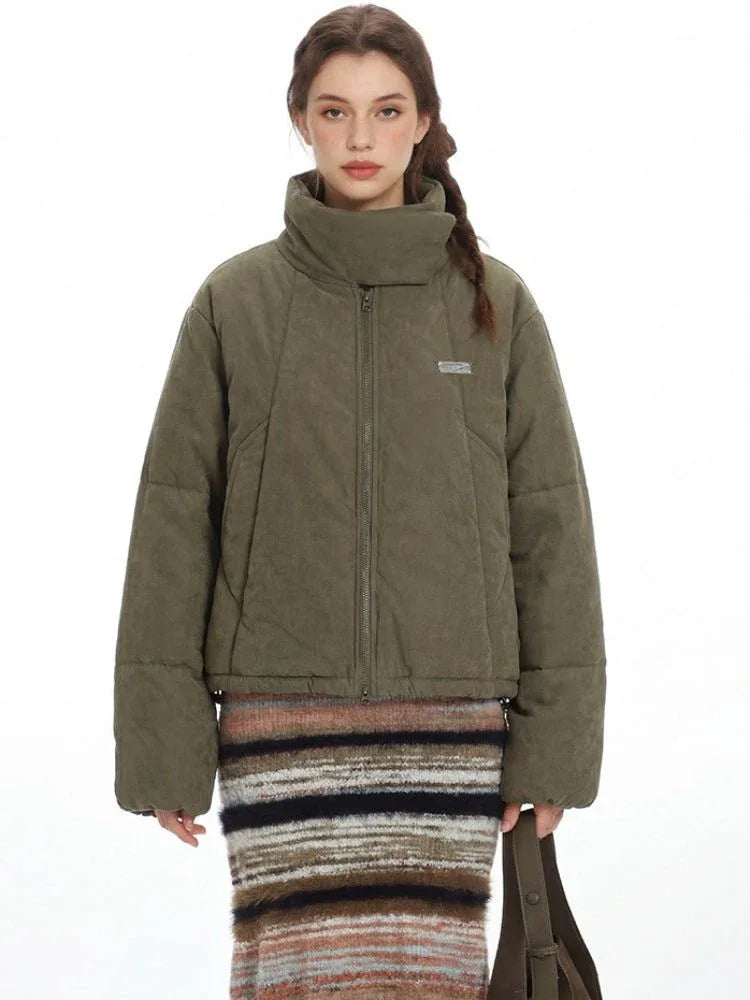 Close-up of the green puffer jacket, highlighting the quilted texture and funnel neck.