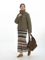 Front view of a woman in a green puffer jacket, showcasing the full design and styling.