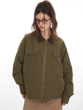 Close-up front view of a woman in an olive green jacket with a brown collar, showcasing pocket details.