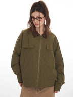 Close-up front view of a woman in an olive green jacket with a brown collar, showcasing pocket details.