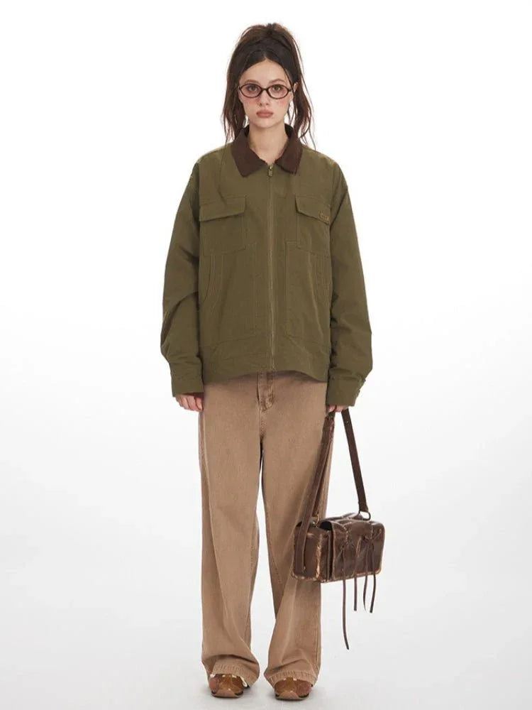 Woman wearing an olive green jacket with a brown collar, paired with tan wide-leg pants and a brown crossbody bag.