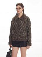 Close-up of a woman wearing a plaid bomber jacket with shearling collar and trim.