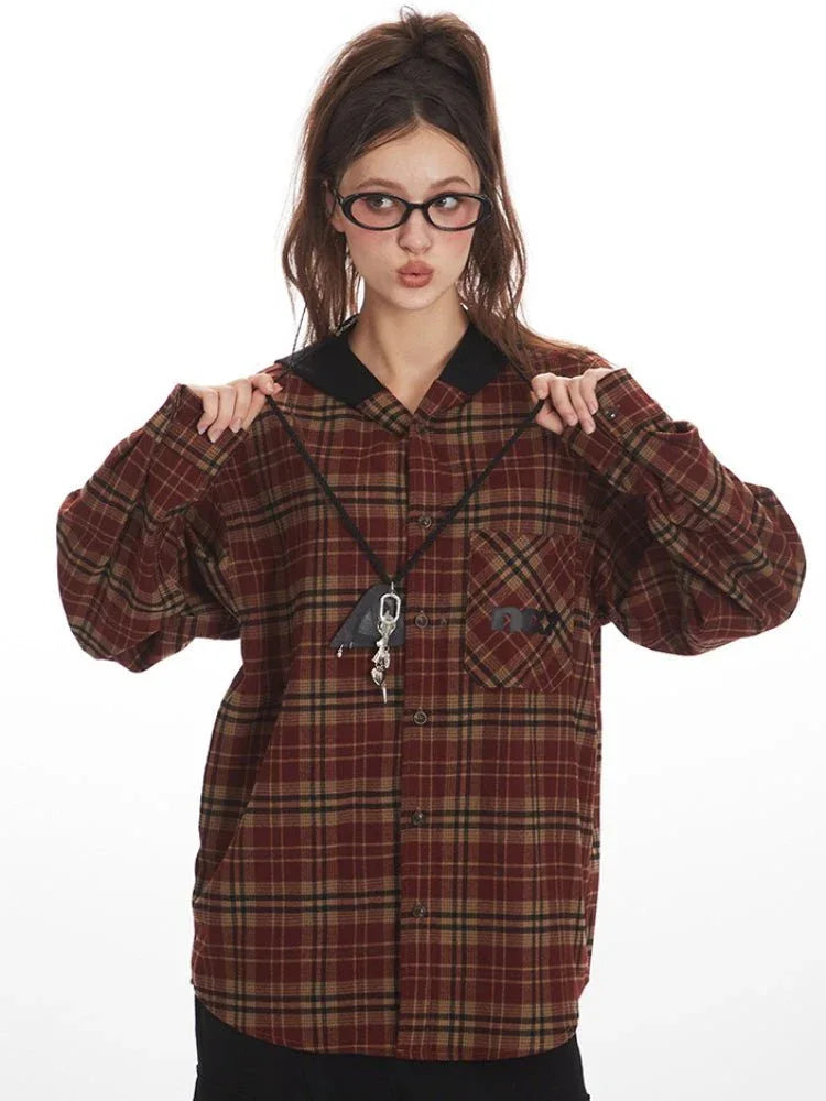 Woman adjusting the collar of her red and tan plaid hooded flannel shirt.