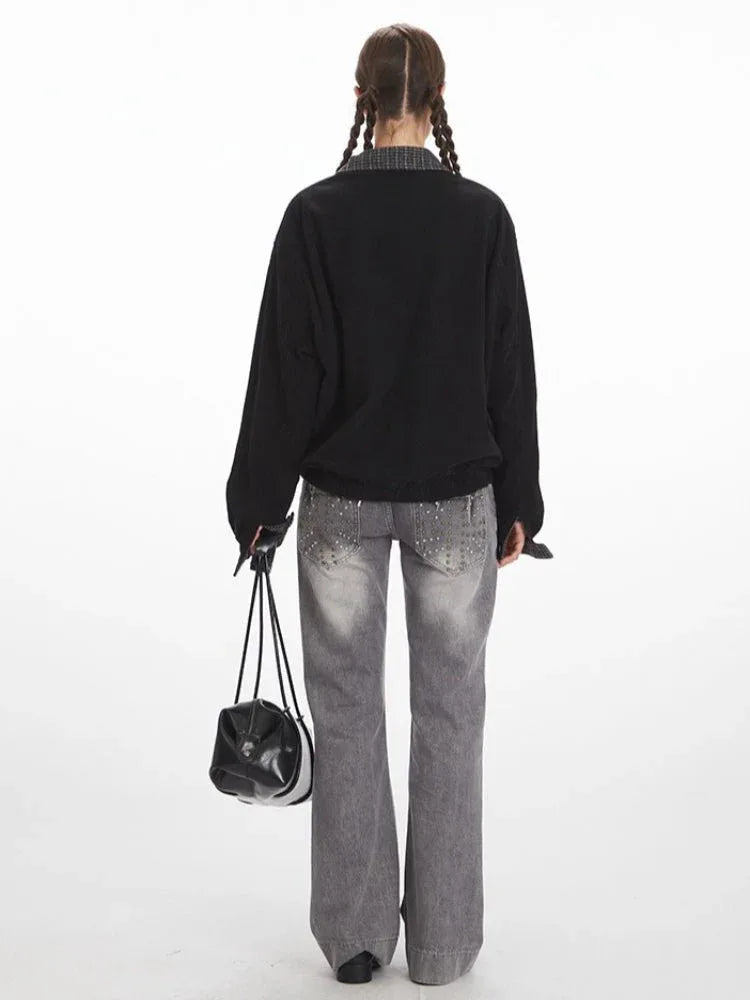 Woman wearing a black bomber jacket with a grey plaid collar and cuffs, paired with grey wide-leg jeans.