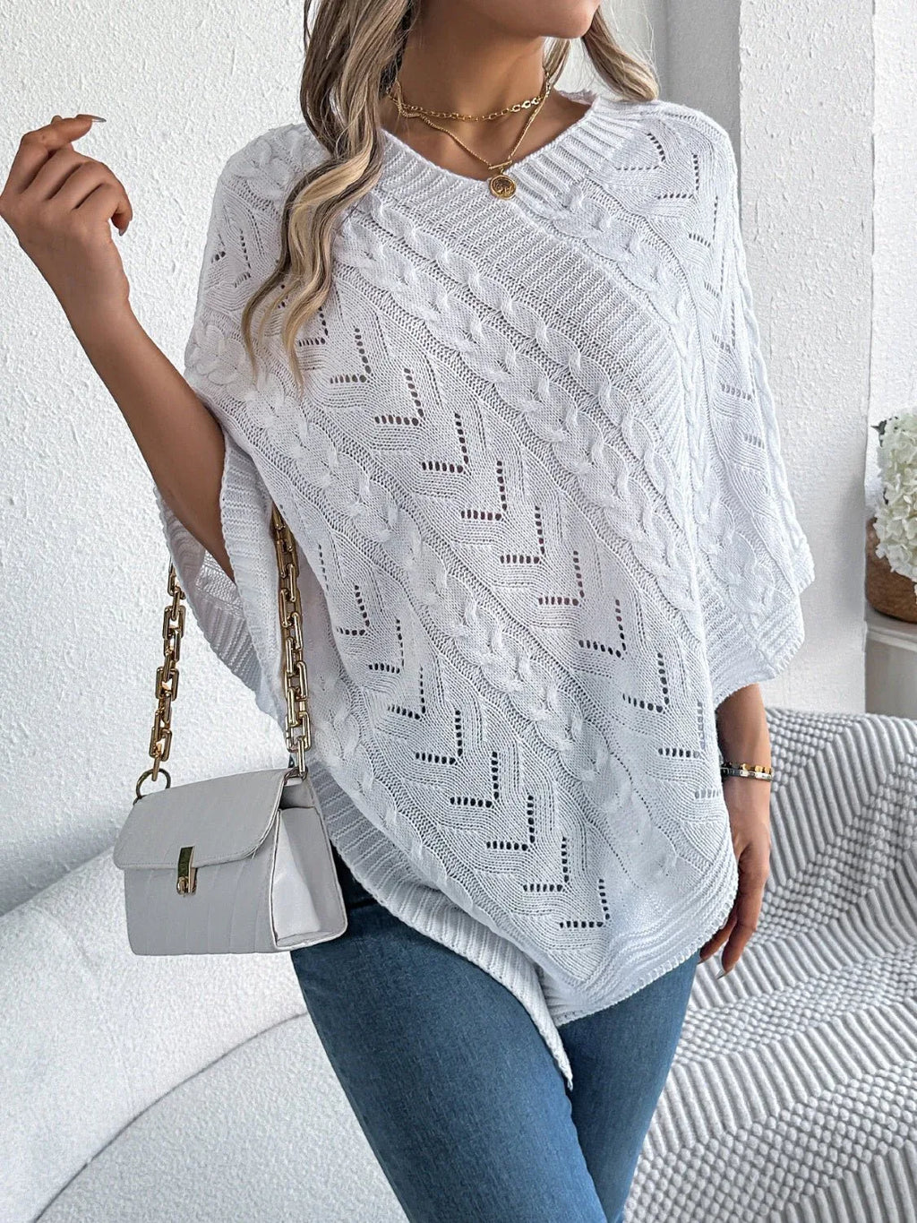 White V-neck knit poncho with cable knit and geometric open-knit detailing.