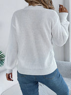 Back view of a woman in a white long-sleeve knit sweater.