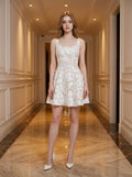 Woman wearing a white sleeveless floral applique short dress with a scoop neckline and a flared skirt.