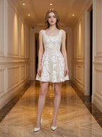 Woman wearing a white sleeveless floral applique short dress with a scoop neckline and a flared skirt.
