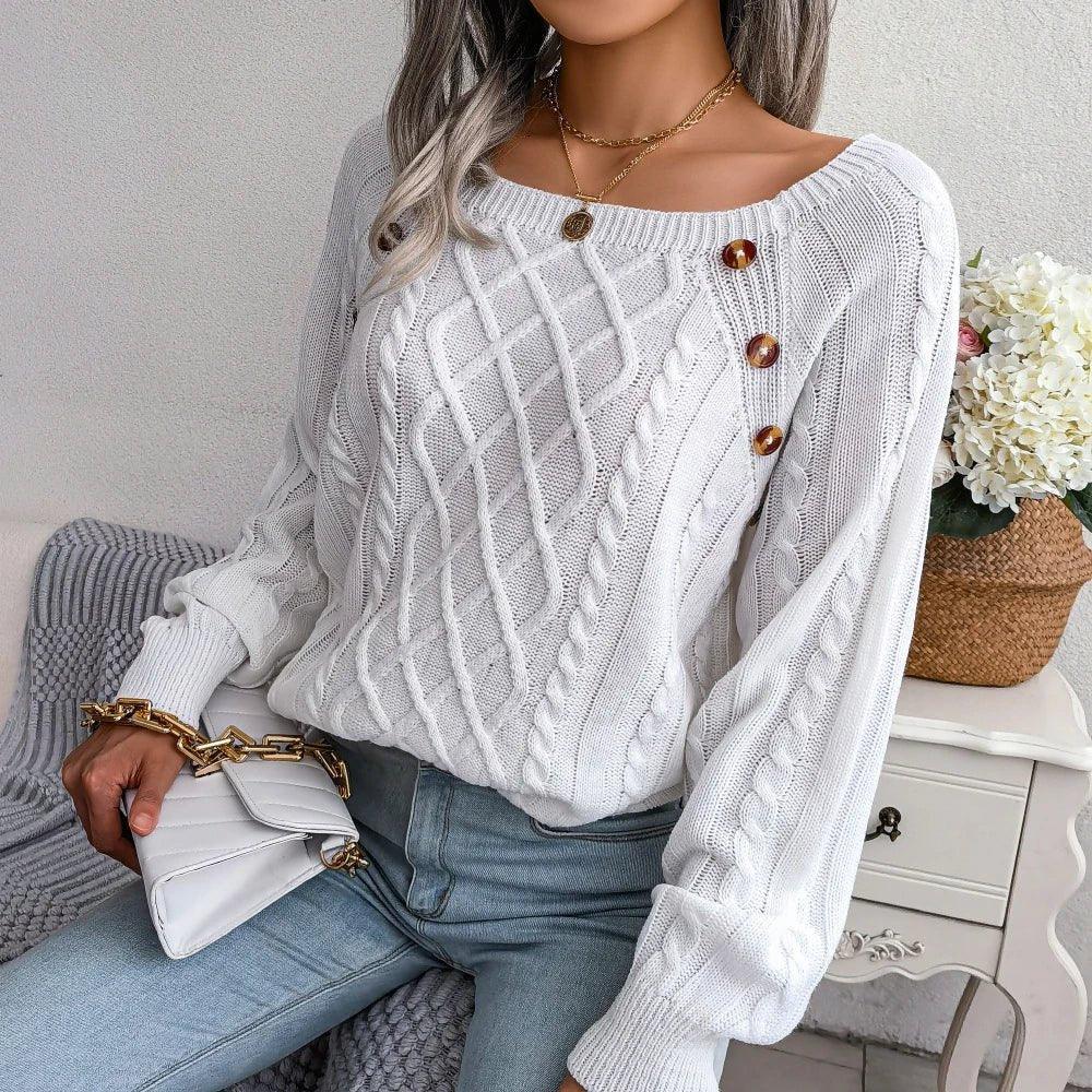 Close-up of the white sweater's intricate cable knit pattern and the placement of brown decorative buttons.