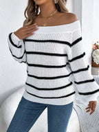 Woman wearing a white and black striped off-the-shoulder knit sweater with blue jeans, touching her chest