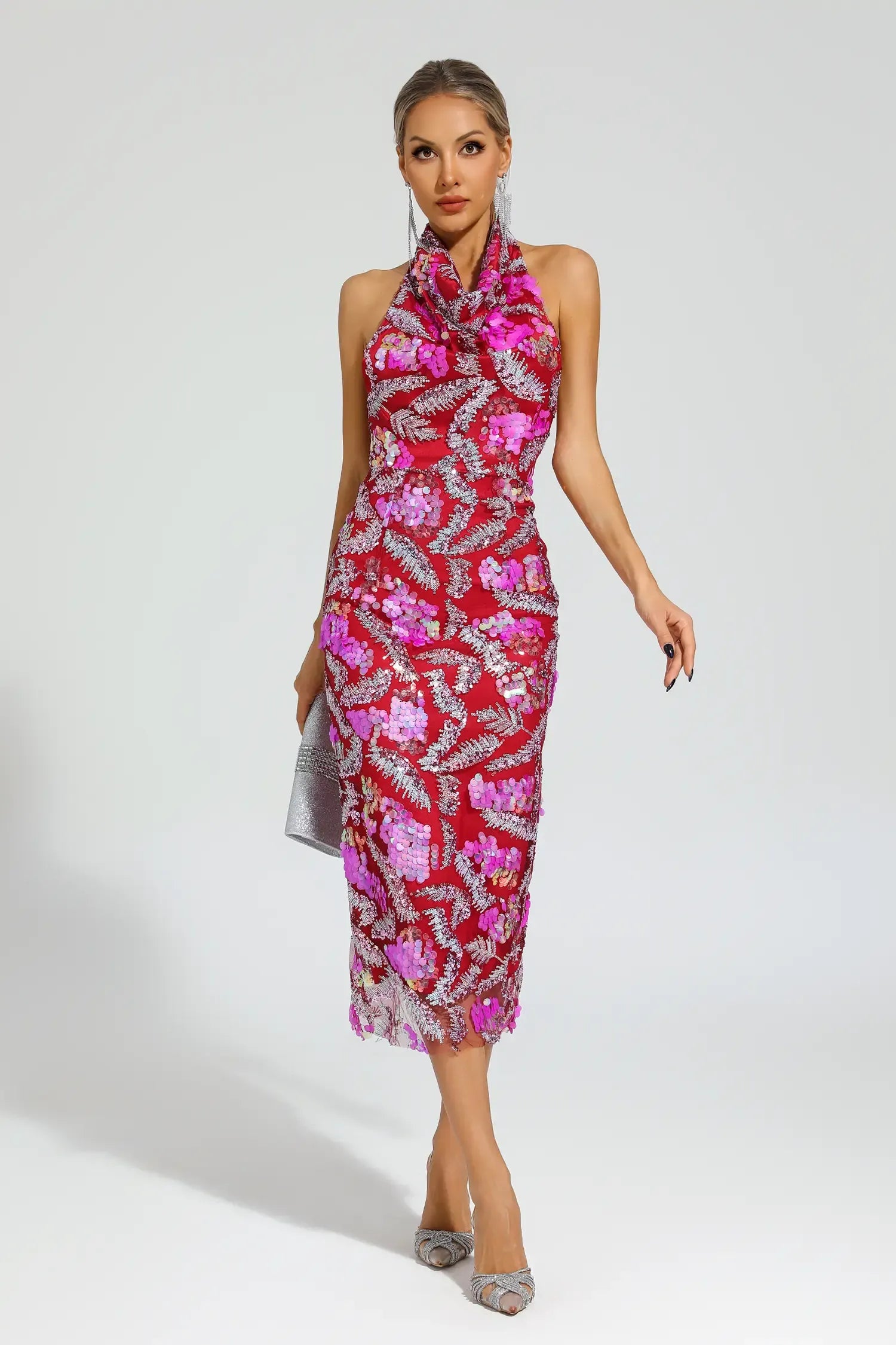 Woman wearing a pink and red patterned dress on a plain background