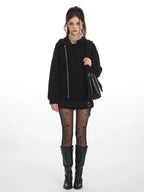 Woman wearing a black textured fleece hoodie with an asymmetrical zipper and hood.