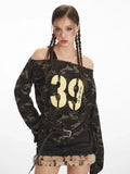 Close-up of a woman's face and upper body, showcasing the camouflage print off-shoulder top with graphic print.