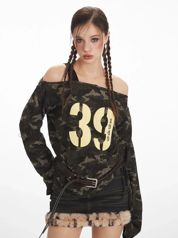 Close-up of a woman's face and upper body, showcasing the camouflage print off-shoulder top with graphic print.