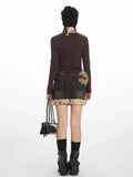 Back view of a model in a brown long-sleeved top and a faux fur-trimmed denim mini skirt.